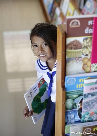 日本から届いた絵本を抱えるカンボジアの少女